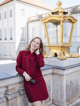 a lady wears a red tweed jacket with a matching mini skirt